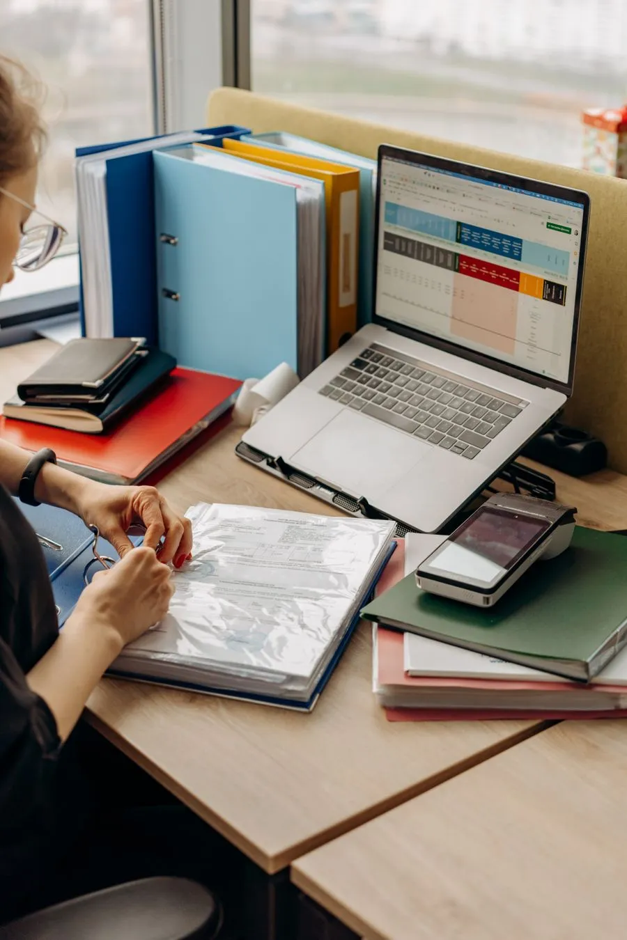 An administrator organizing compliance records at a desk