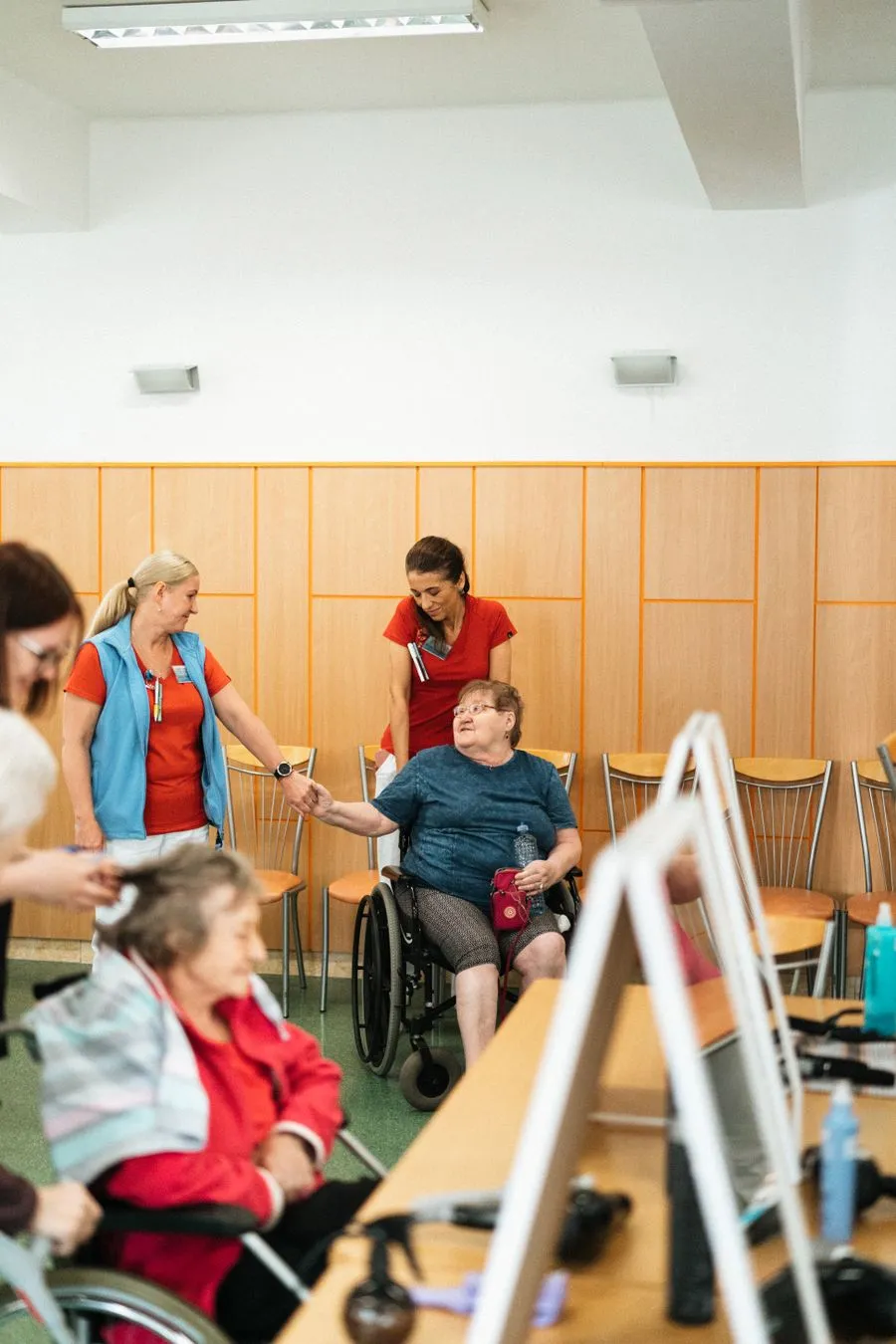 Care staff warmly greeting residents in a community room
