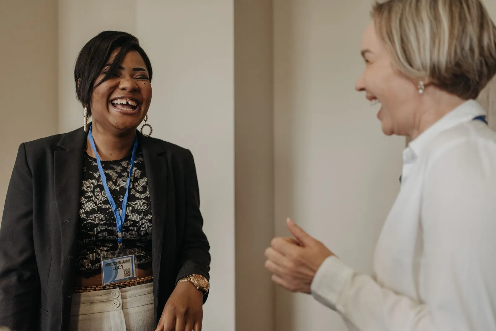 Two conference attendees laughing together between sessions