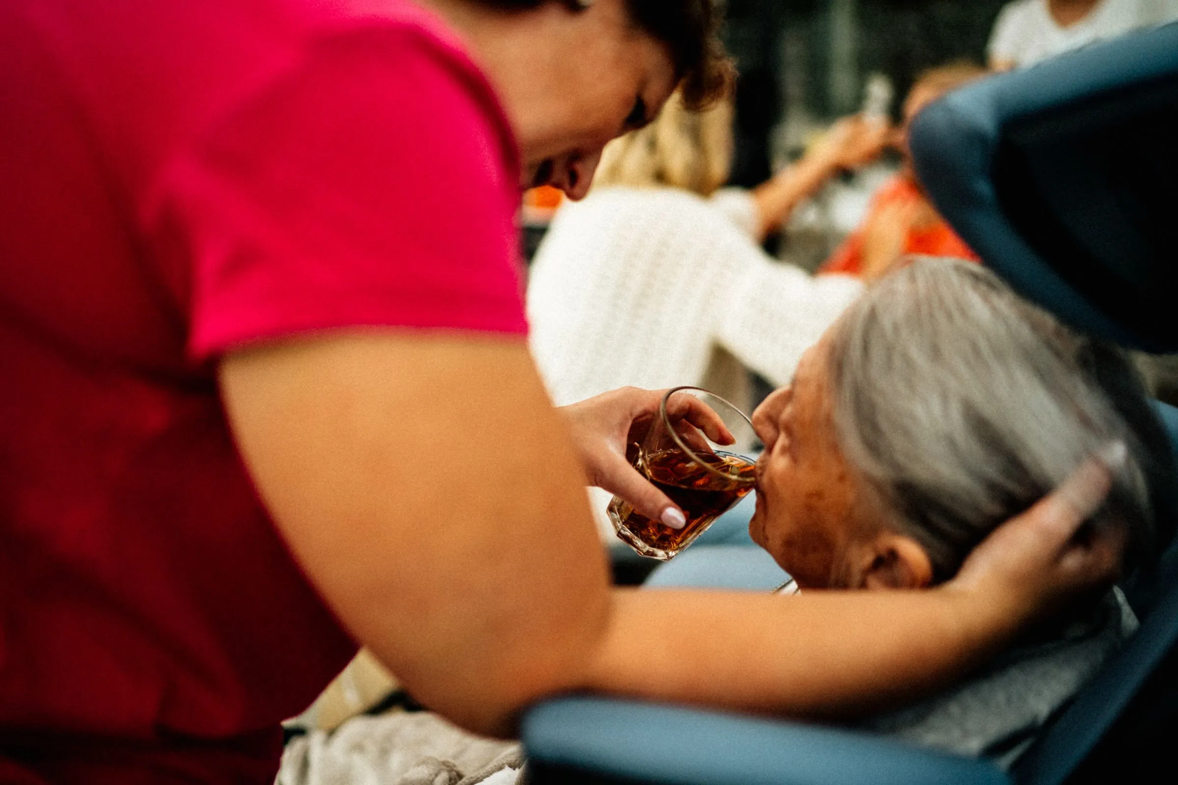 A caregiver sharing a warm moment with an older woman over tea