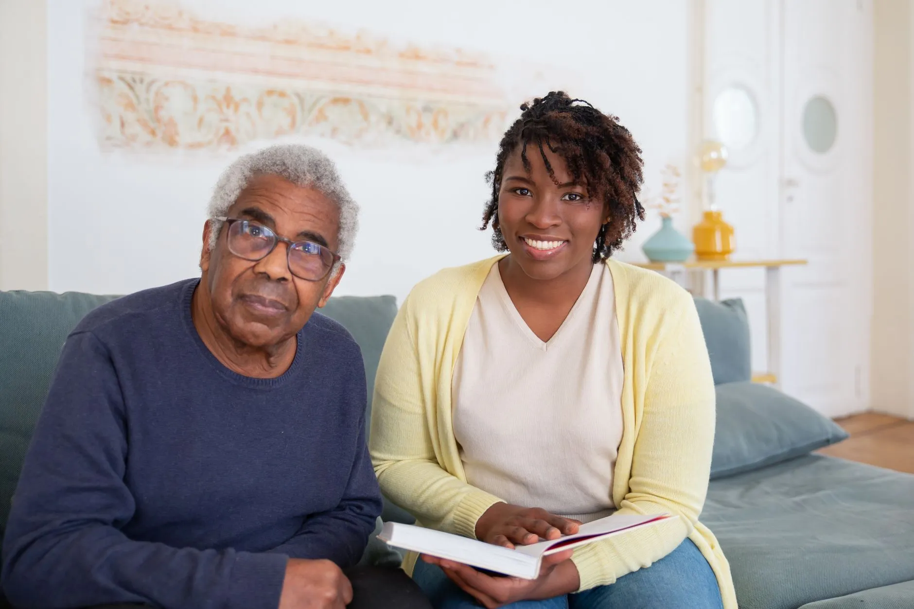 An older man and a care worker sitting together at home, going through a care plan