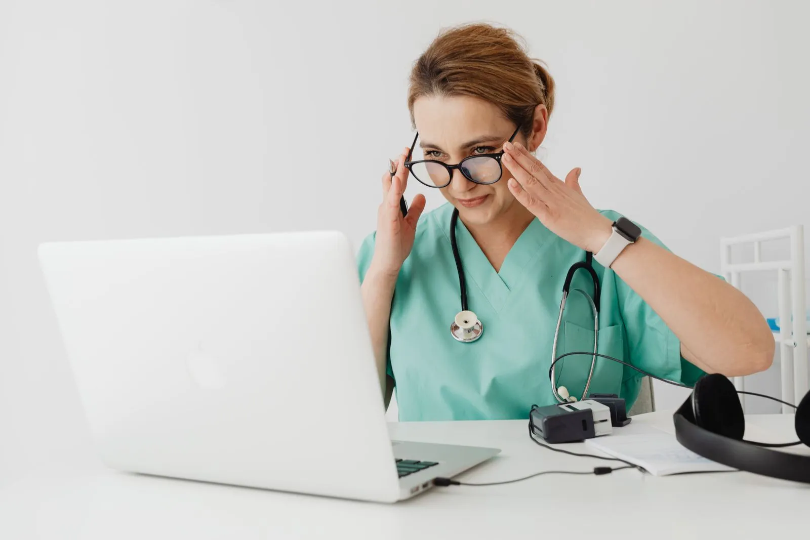 A nurse reviewing records on a laptop