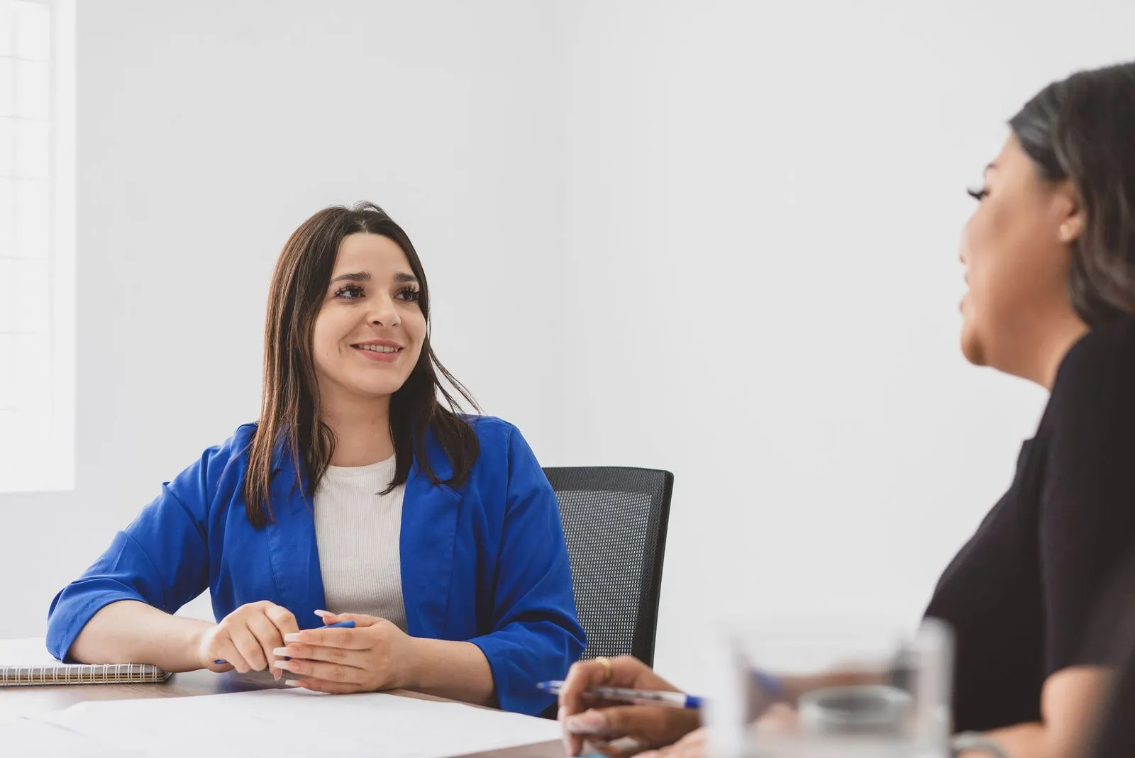 An administrator talking through a compliance plan with a colleague across a desk