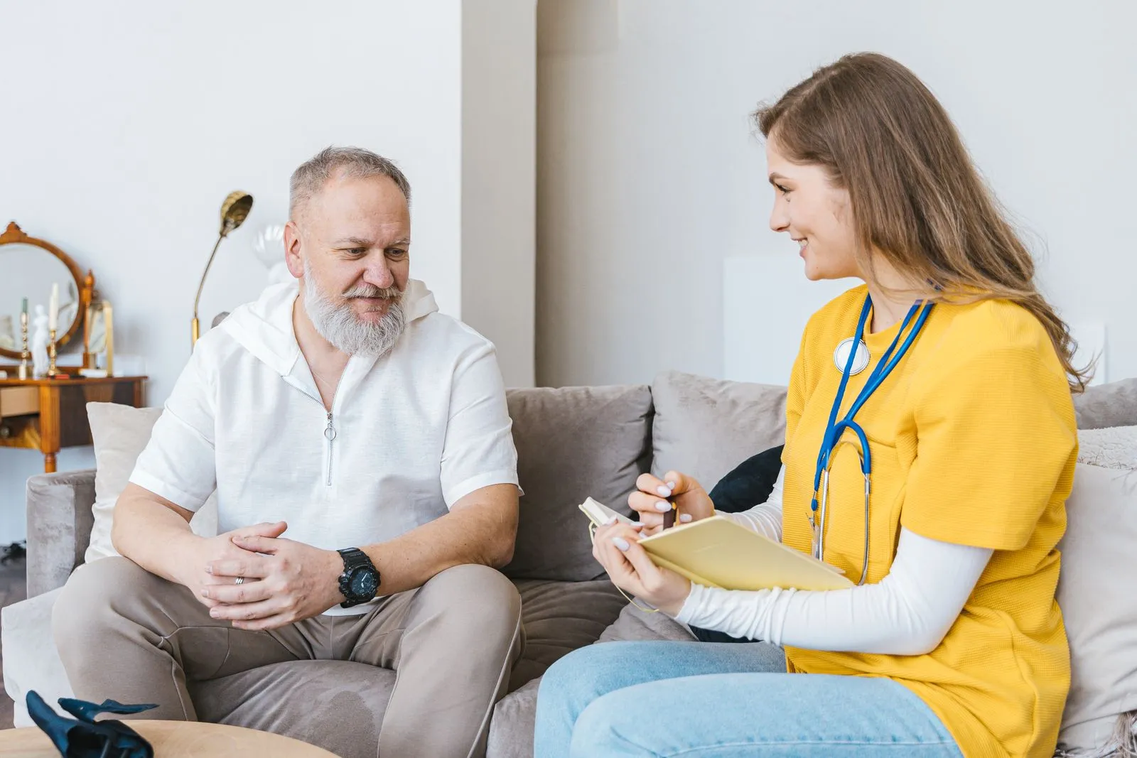 An RN reviewing care with a senior in his home