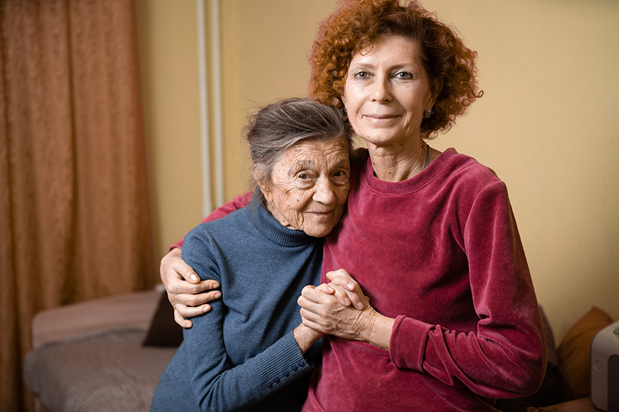 caring for aging parents woman hugging elderly mom - Engagement Through Education | Assisted Living Classes