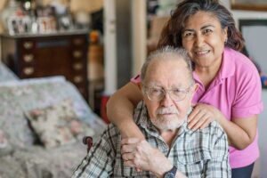 caring for our caregivers, hispanic woman hugging elderly man - Engagement Through Education | Assisted Living Classes