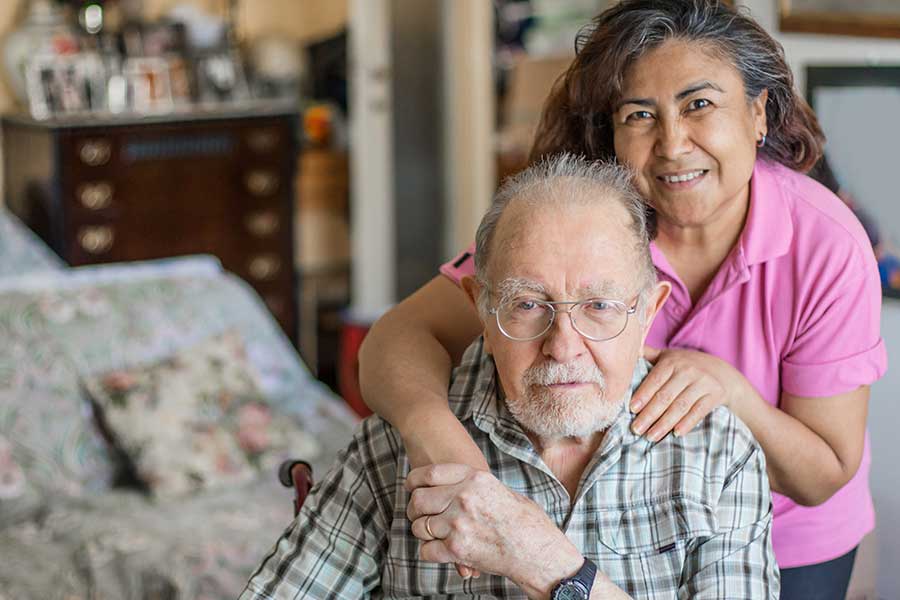 caring for our caregivers, hispanic woman hugging elderly man