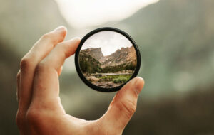 5 ways to sharpen your focus hand holding magnifying glass up close mountains