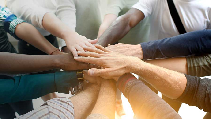 how to build trust in the workplace...diverse group all hands in Engagement Through Education | Assisted Living Classes