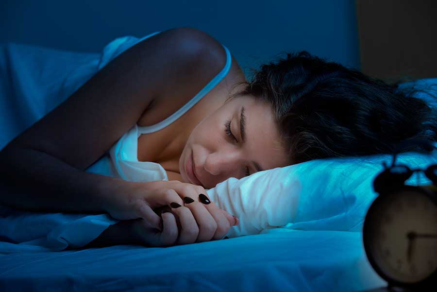 Wellness through sleep and how to wake up on the right side of the bed. woman sleeping in bed